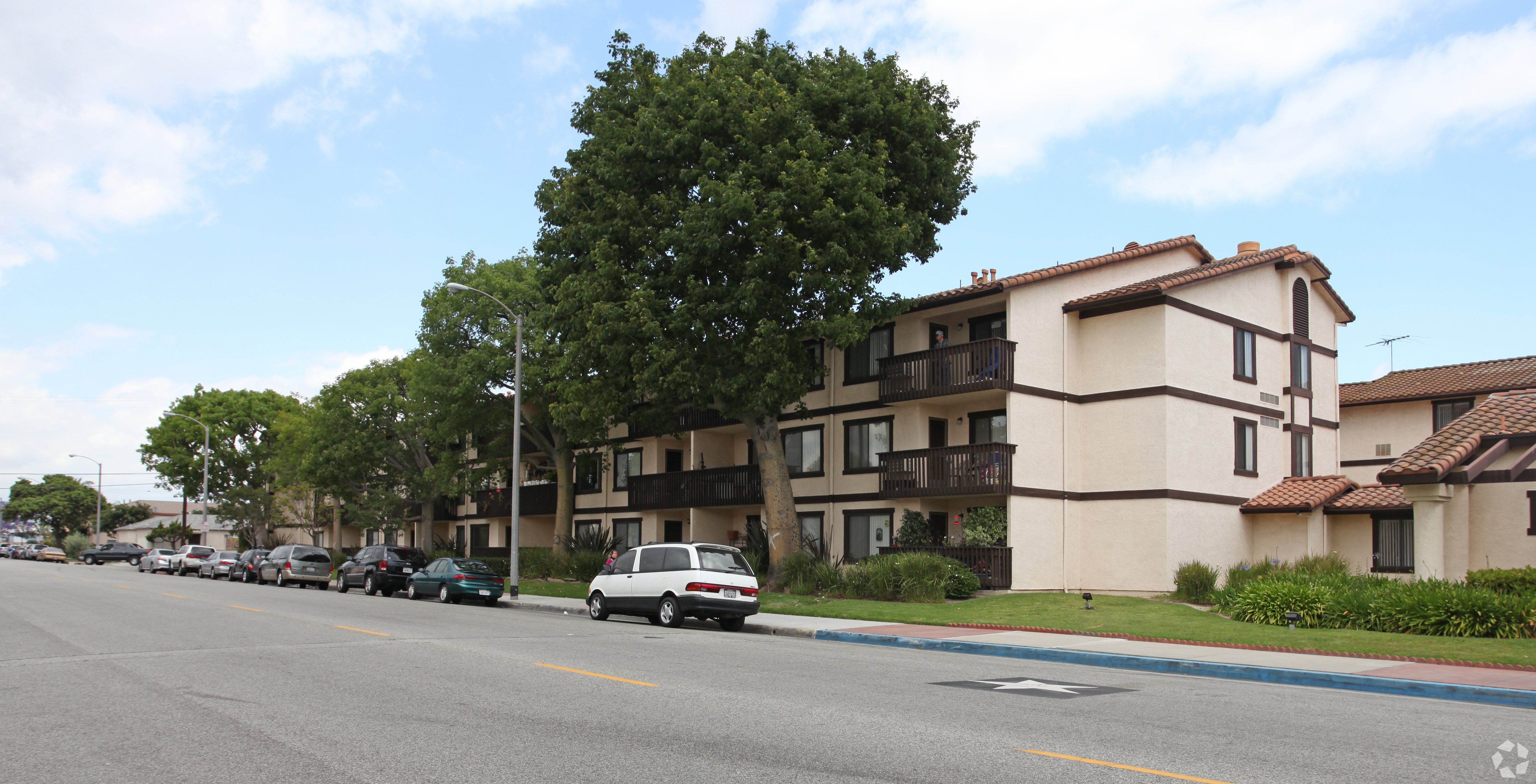 A street with cars and apartment buildings.